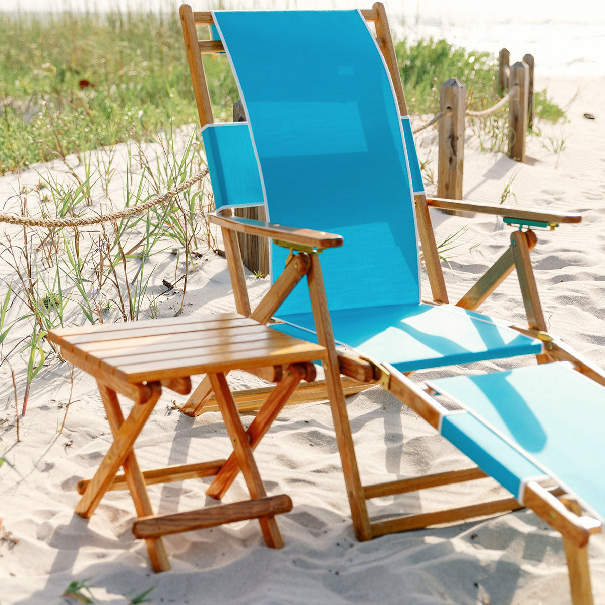 Coastsetter Folding Table on the sand beside a blue beach chair