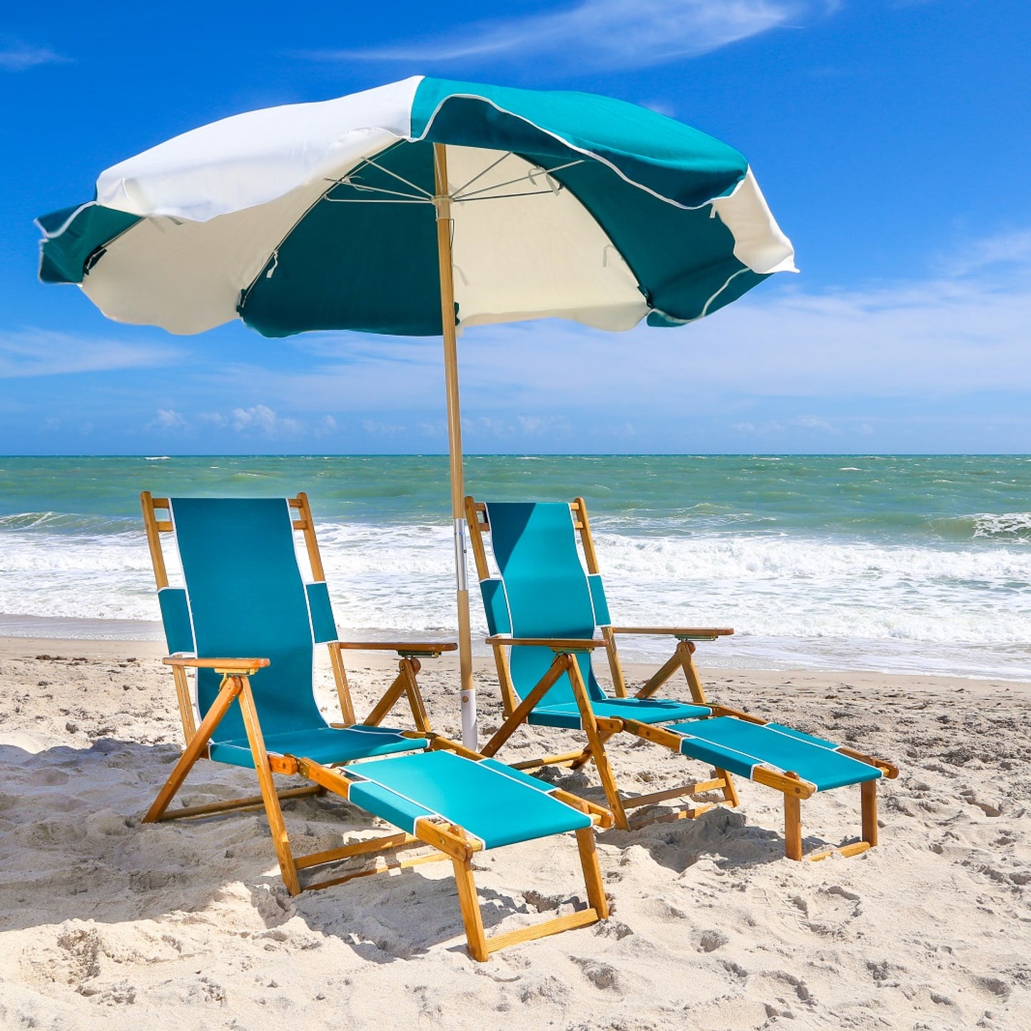 A pair of Coastsetter Beach Chairs in Aqua Marine reclined under a striped beach umbrella