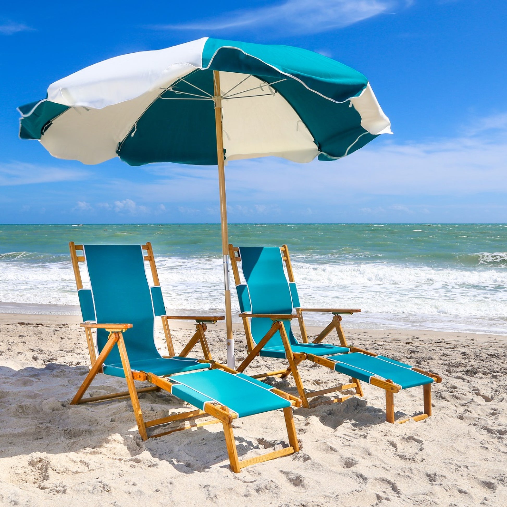 A pair of Coastsetter Beach Chairs in Aqua Marine reclined under a striped beach umbrella