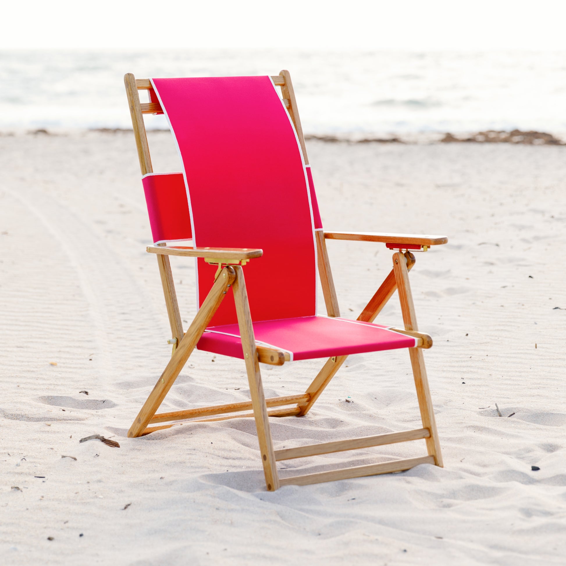 Coastsetter Beach Chair in Jockey Red on the sand, upright without a leg rest