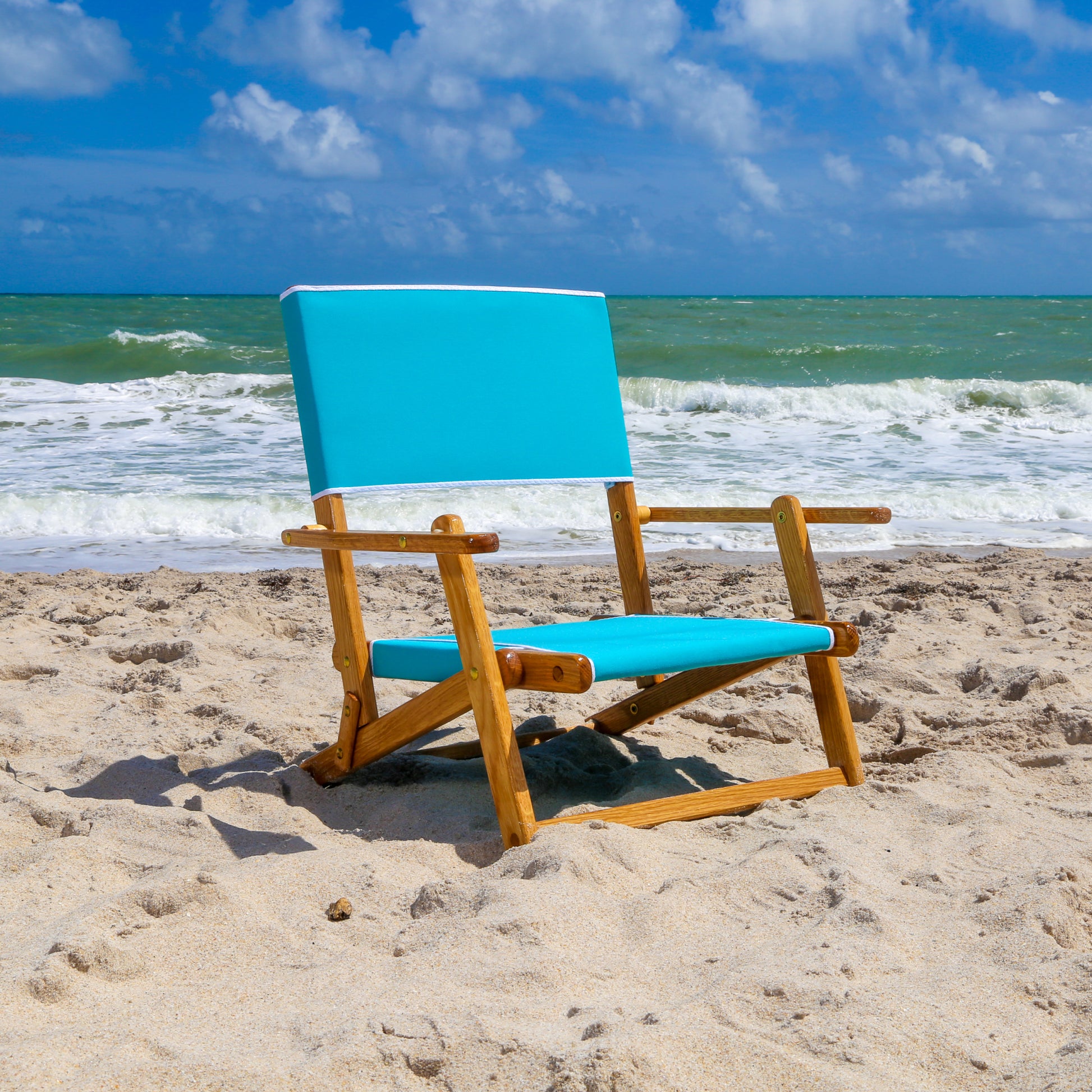 Coastsetter Sand Chair in Turquoise, sitting low to the sand