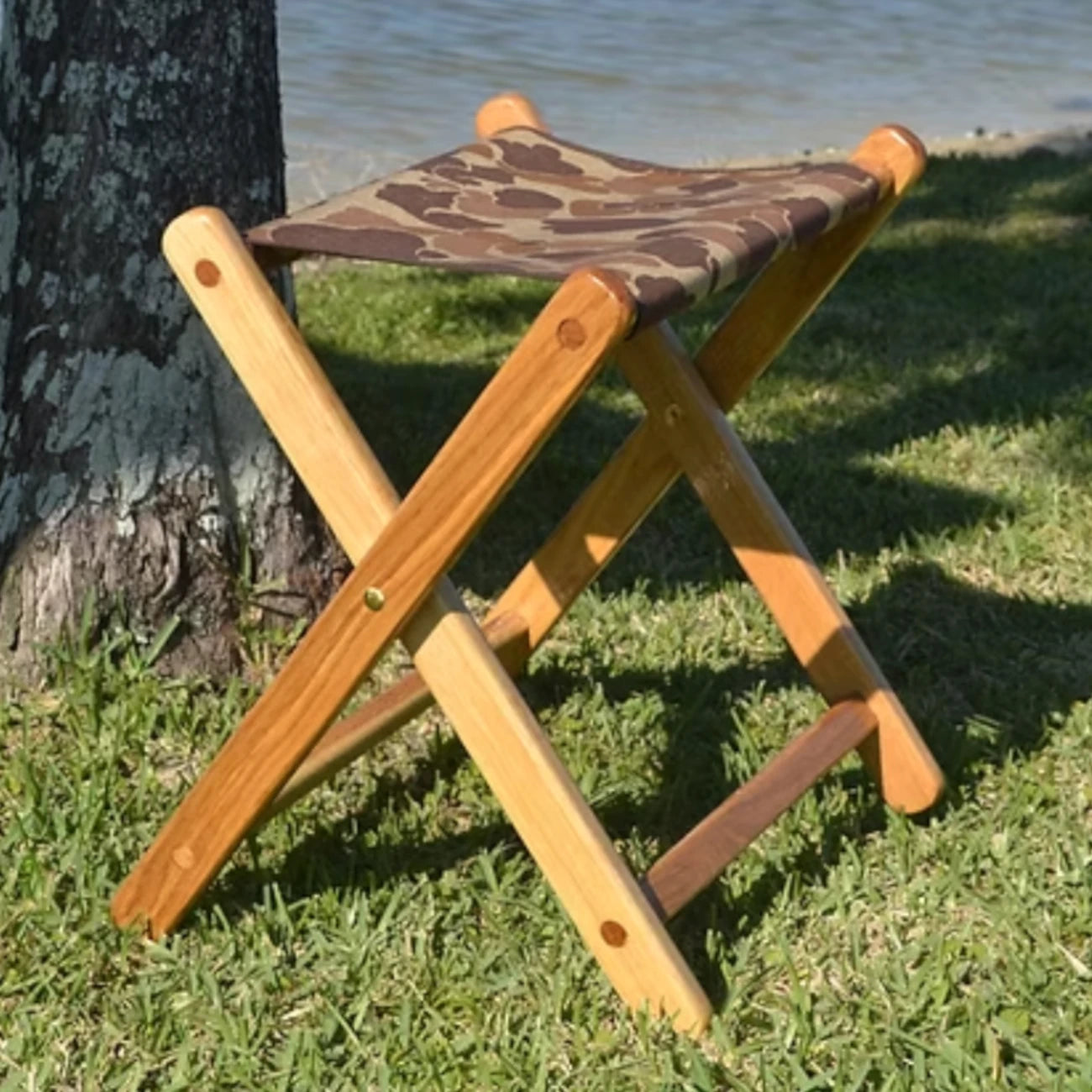 Coastsetter Camp Stool in white oak with a canvas seat, on grass